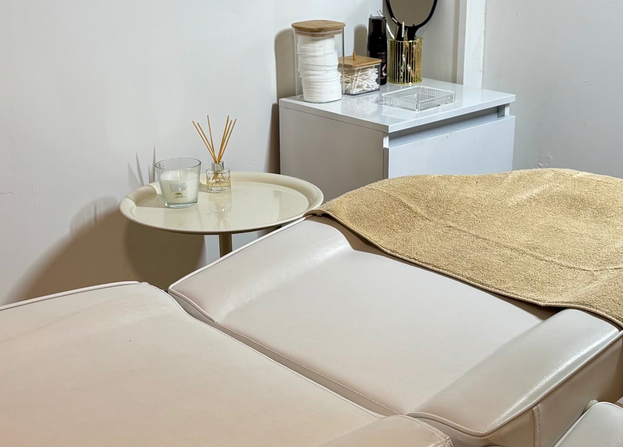 Cabina de tratamiento en Beautify, Bootle, England, GB, con mesa de masaje blanca y decoración relajante.