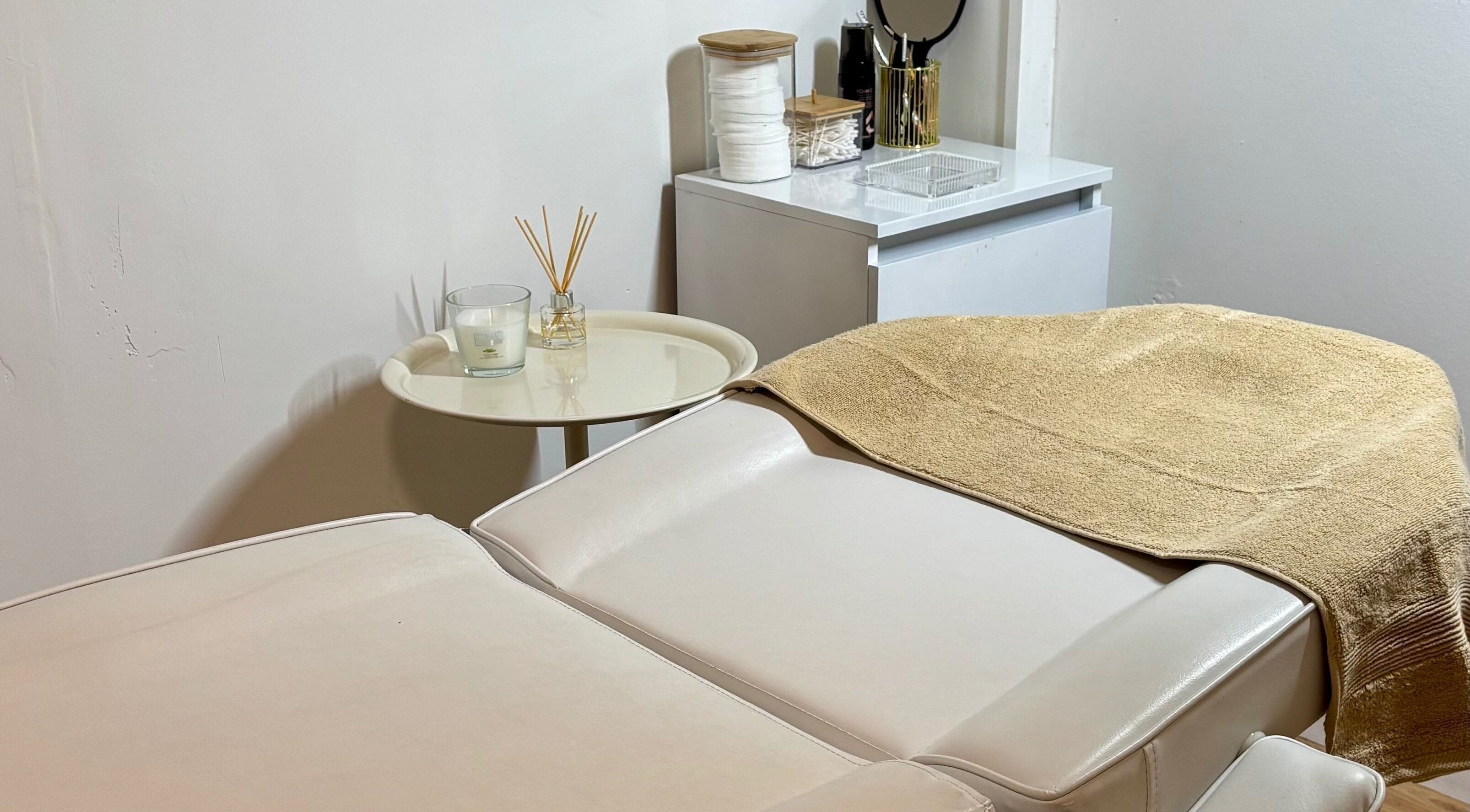 Cabina de tratamiento en Beautify, Bootle, England, GB, con mesa de masaje blanca y decoración relajante.