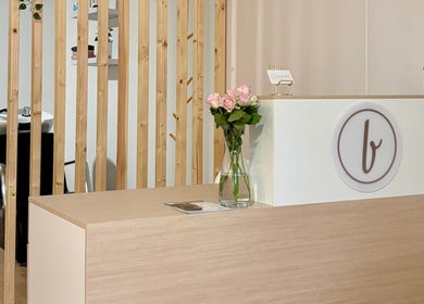 Mostrador de recepción elegante en Beautify, Bootle, England, GB, con flores y diseño moderno.