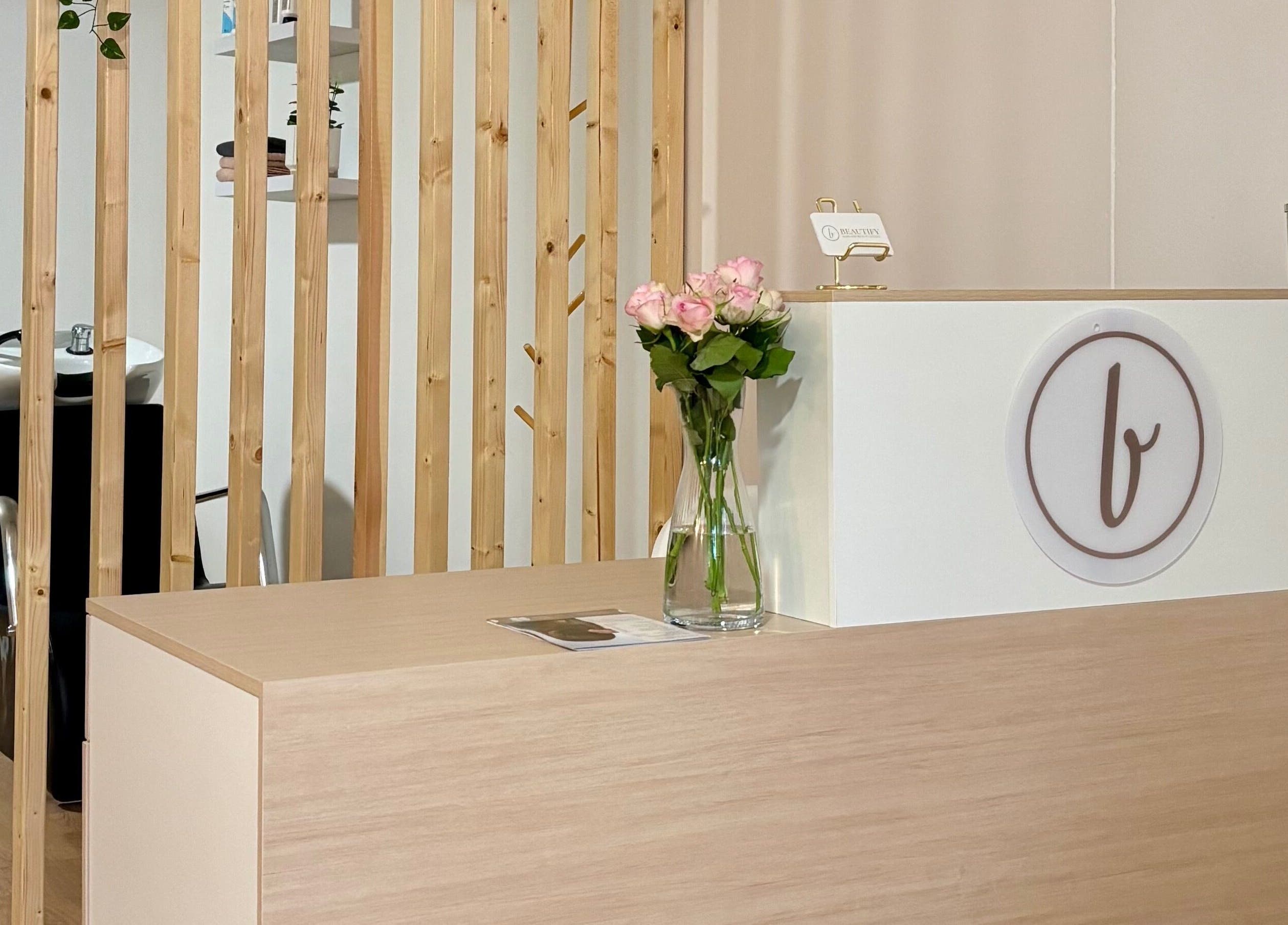 Mostrador de recepción elegante en Beautify, Bootle, England, GB, con flores y diseño moderno.