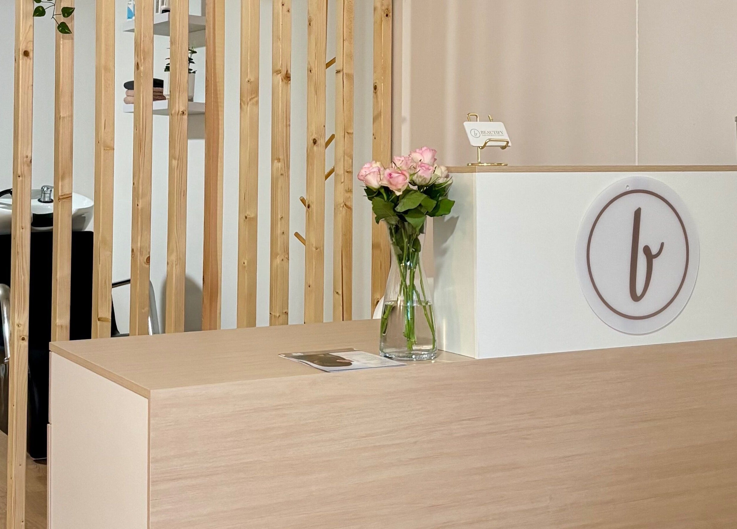 Mostrador de recepción elegante en Beautify, Bootle, England, GB, con flores y diseño moderno.