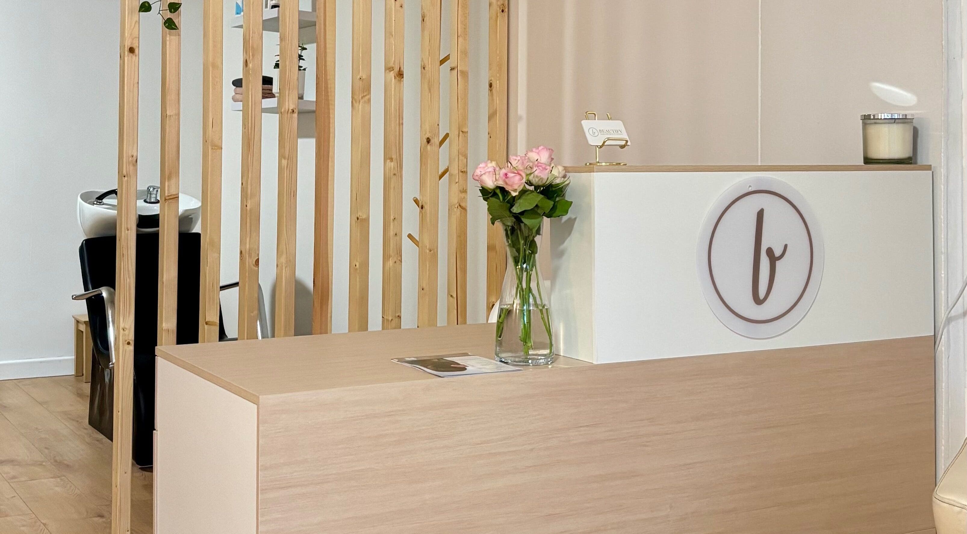 Mostrador de recepción elegante en Beautify, Bootle, England, GB, con flores y diseño moderno.