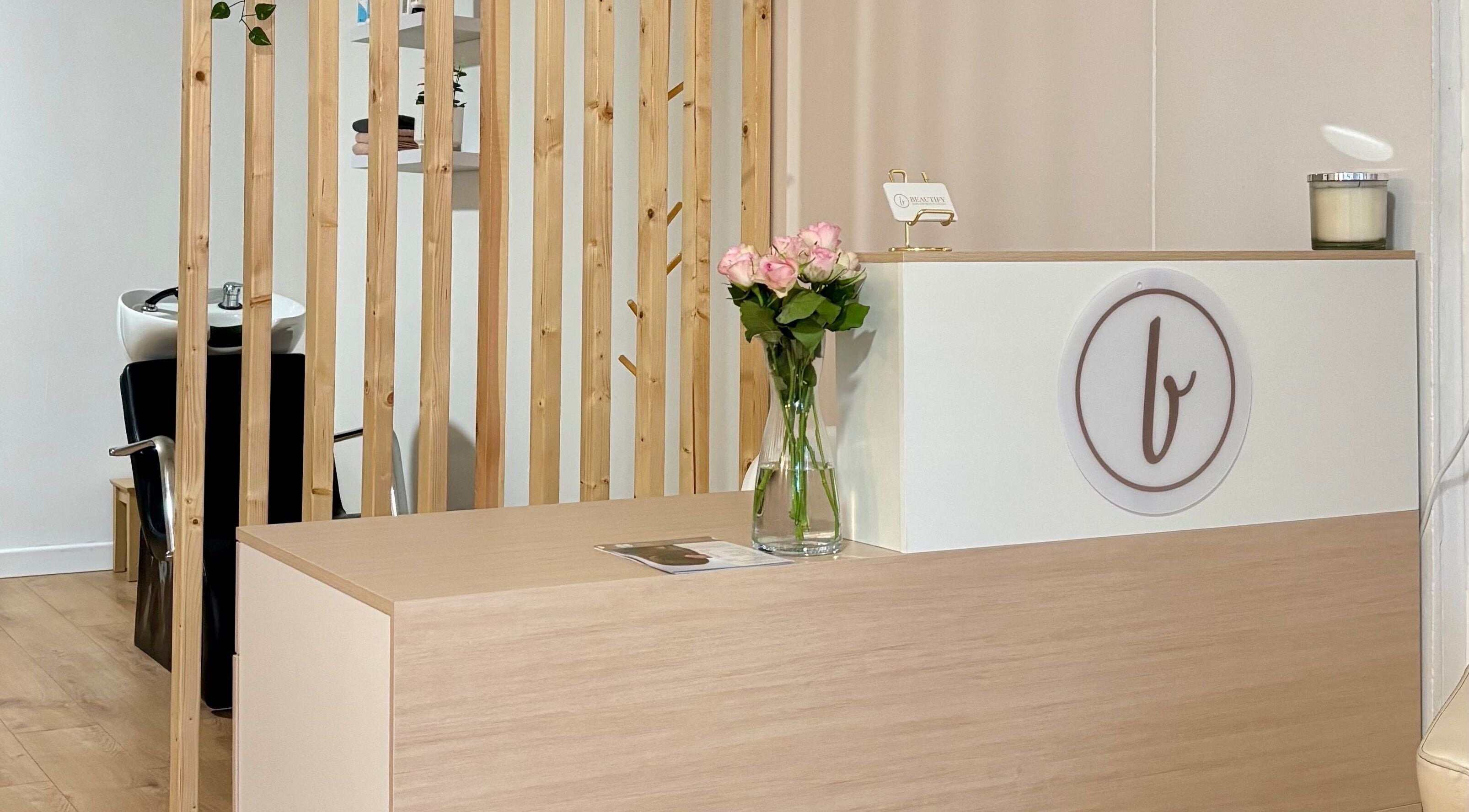 Mostrador de recepción elegante en Beautify, Bootle, England, GB, con flores y diseño moderno.
