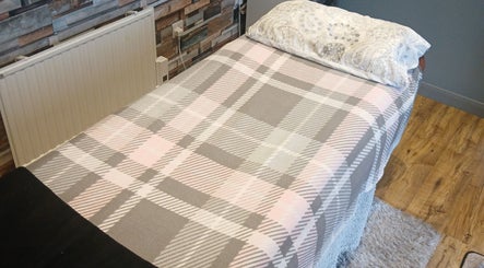 Comfortable therapy bed setup at Pennine Silhouette in Thurgoland, England, GB with plaid bedding.