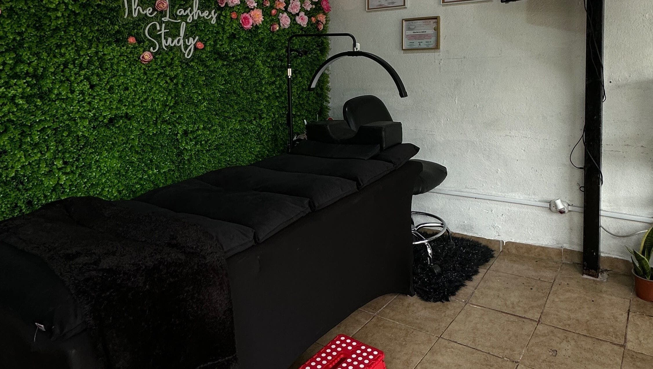 Espacio relajante en The Lashes Study, Monterosa, Heredia, CR, con camilla negra y decoraciones florales.