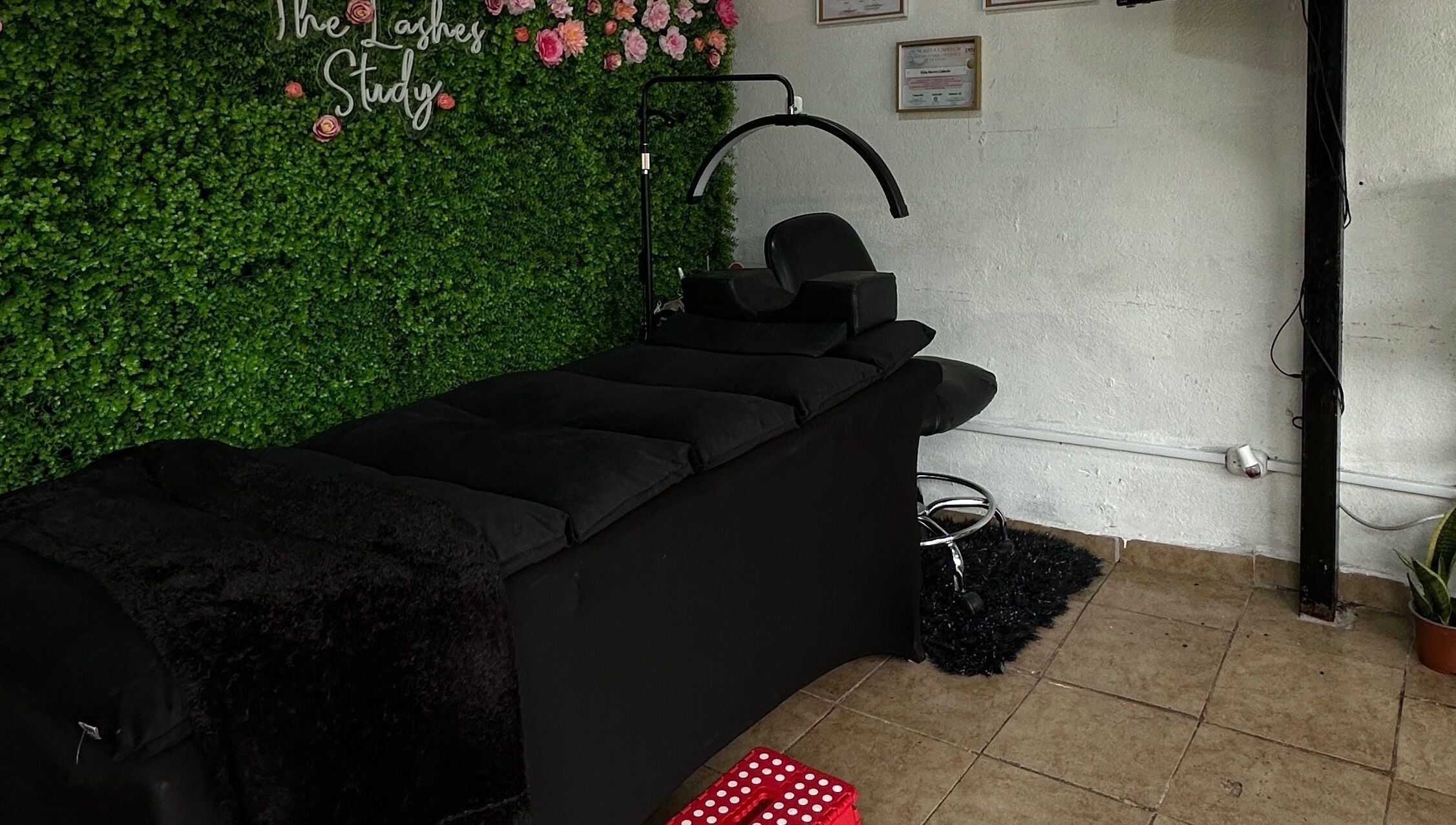Espacio relajante en The Lashes Study, Monterosa, Heredia, CR, con camilla negra y decoraciones florales.