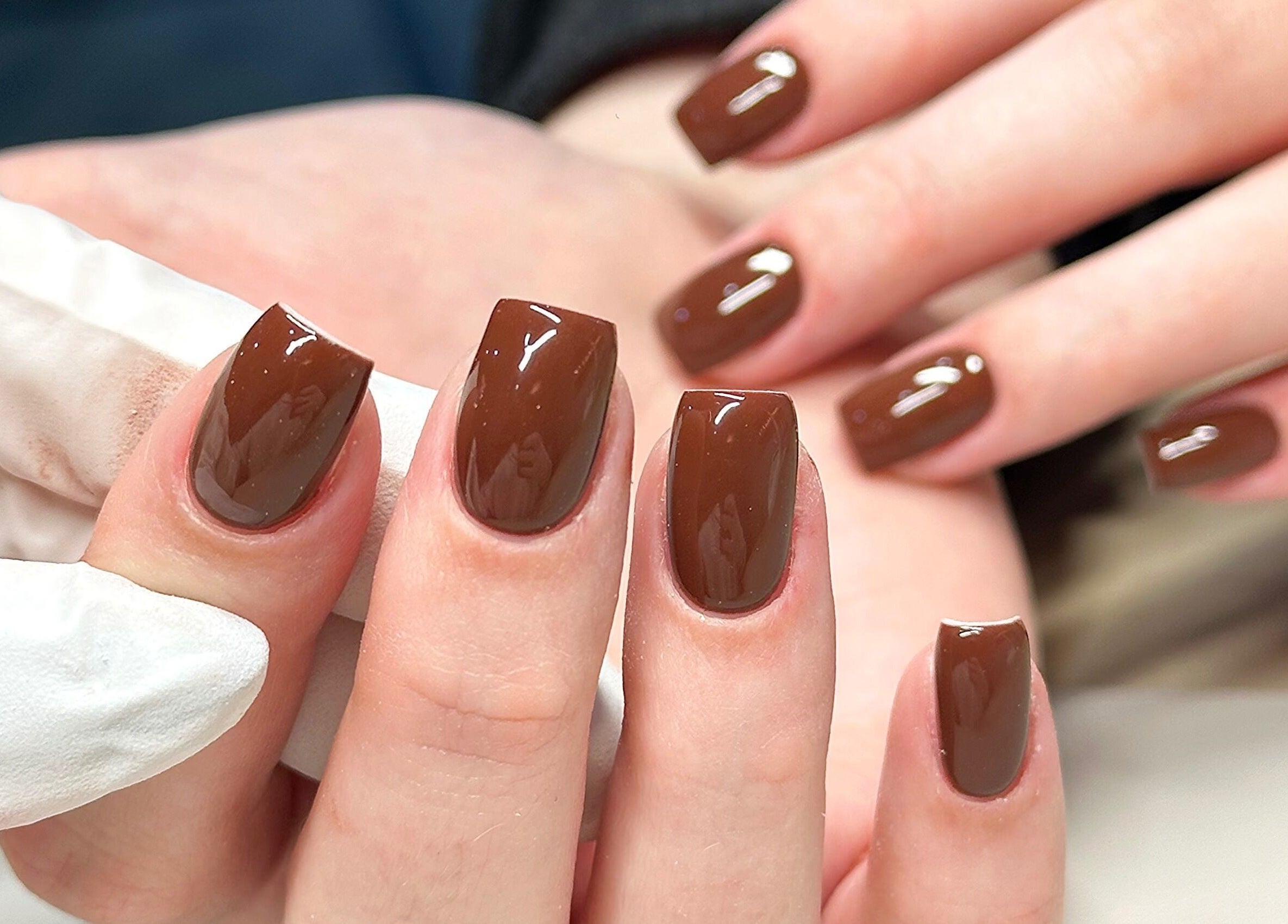 Elegant brown manicure at Bydarcyella, Birmingham, England, GB showcasing glossy finish.