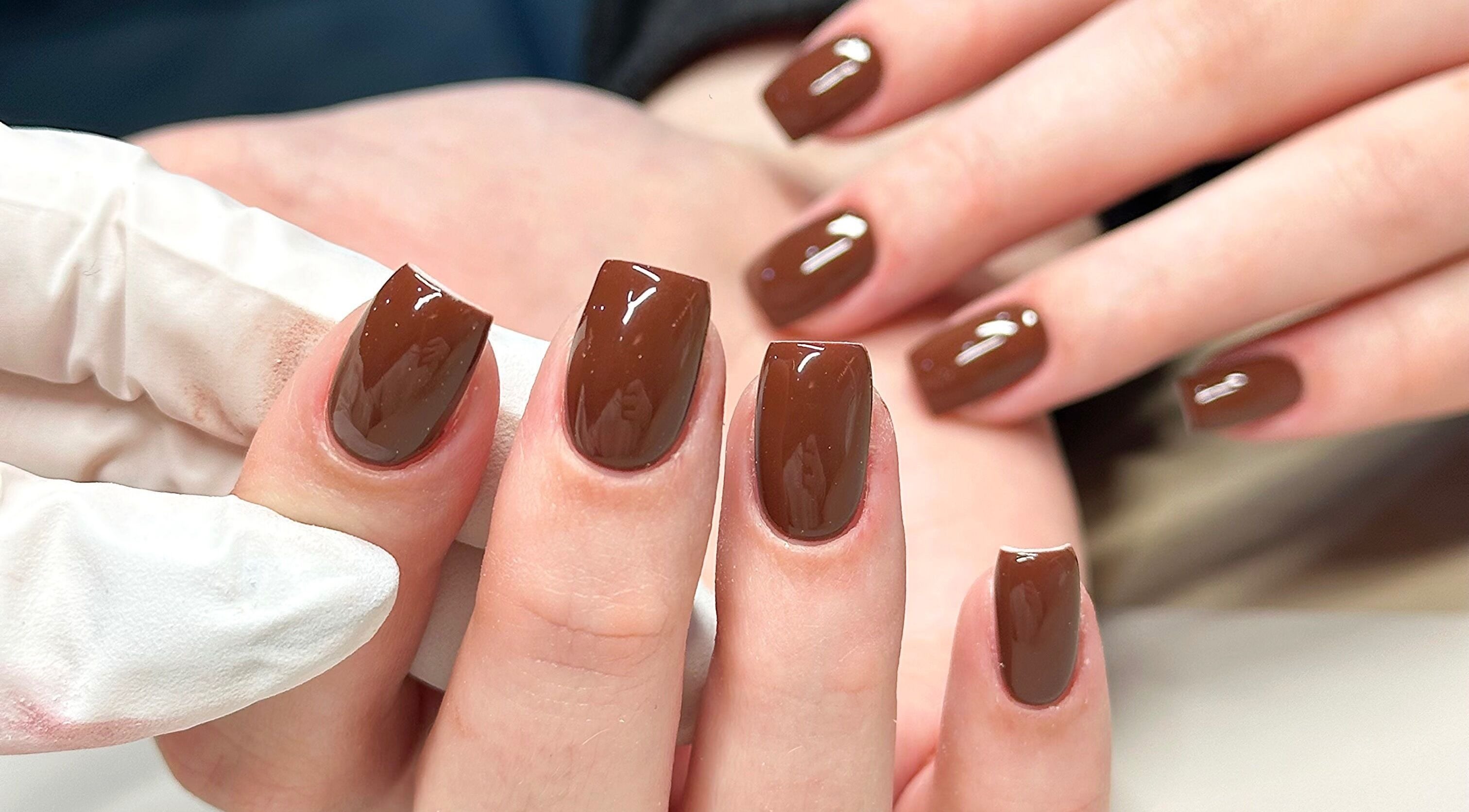 Elegant brown manicure at Bydarcyella, Birmingham, England, GB showcasing glossy finish.