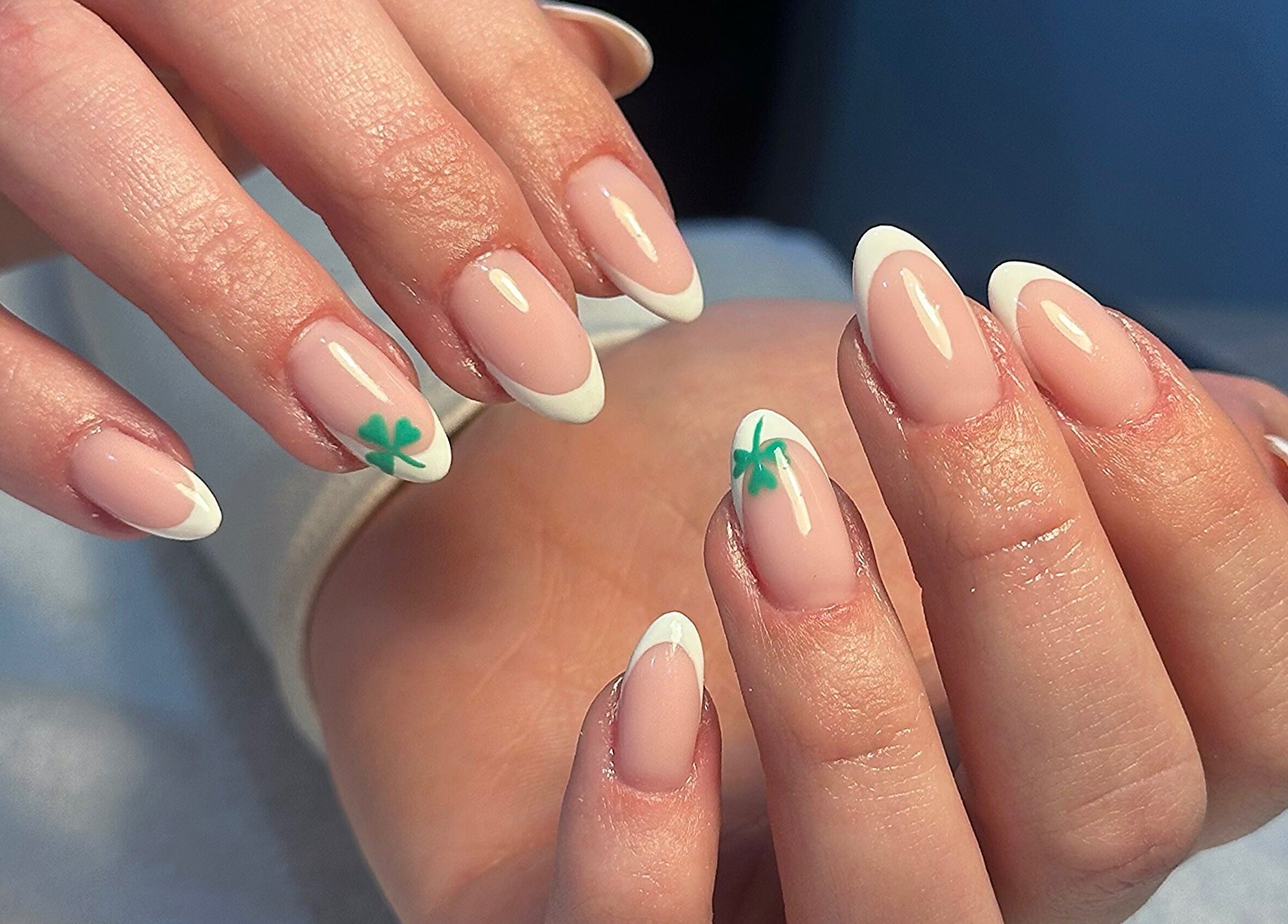 Stylish French manicure with clover art at Bydarcyella, Birmingham, England, GB.