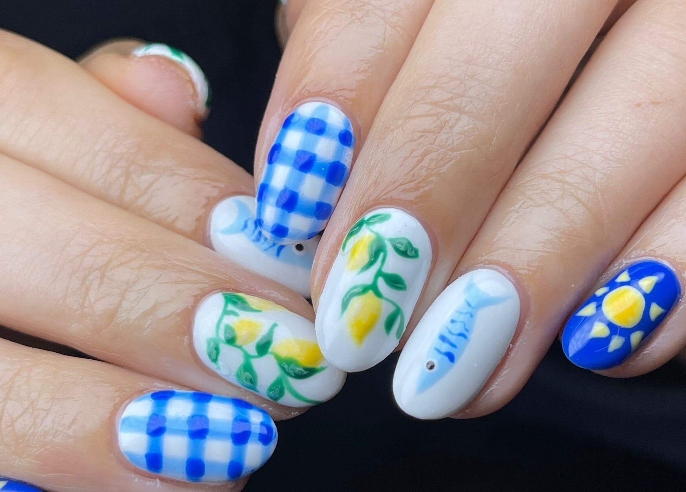 Colorful nail art at Fashi0n.Victim, Manchester, England, GB featuring blue checks and floral designs.