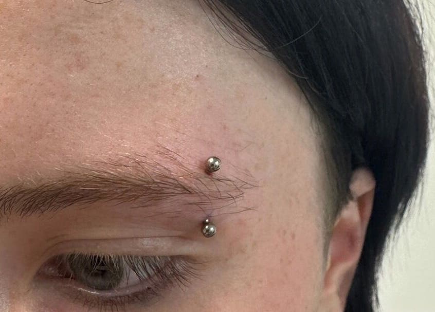 Eyebrow piercing at Selina Janes, Ayr, Scotland, GB enhances facial expression with stylish metal studs.