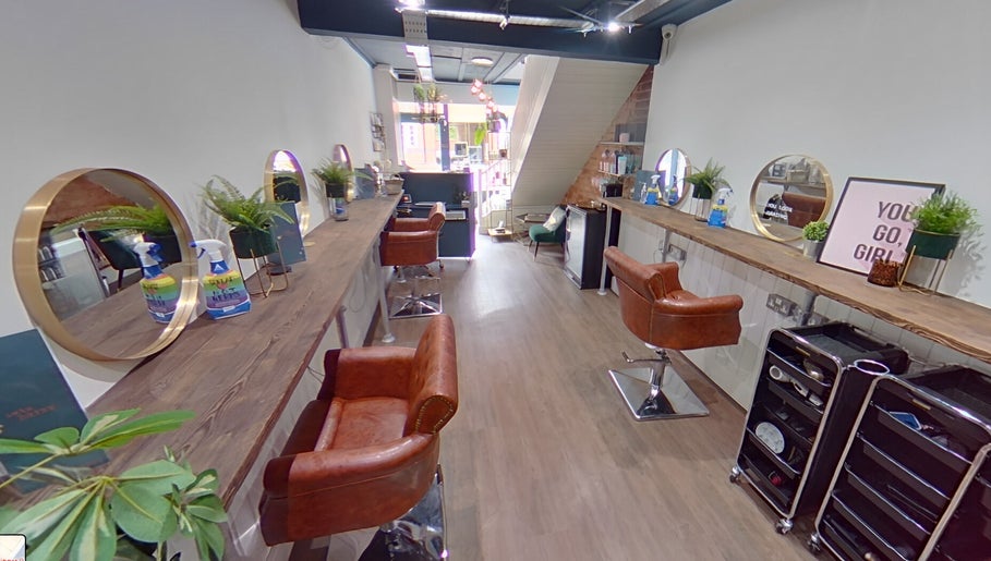 Trendy interior of Salon Pickle in Bromsgrove, England, showcasing elegant styling stations and decor.