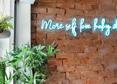 Neon sign with greenery inside Salon Pickle, Bromsgrove, England, GB, creating a calming space.