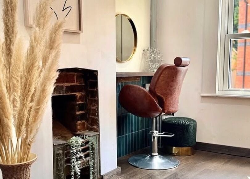Elegant styling chair beside decorative vase at Salon Pickle, Bromsgrove, England, GB.