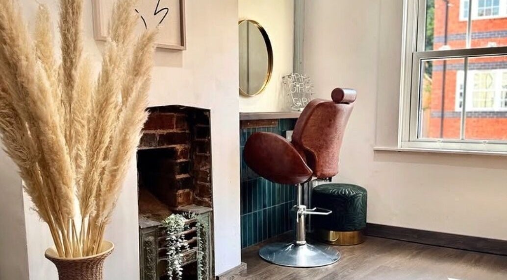 Elegant styling chair beside decorative vase at Salon Pickle, Bromsgrove, England, GB.