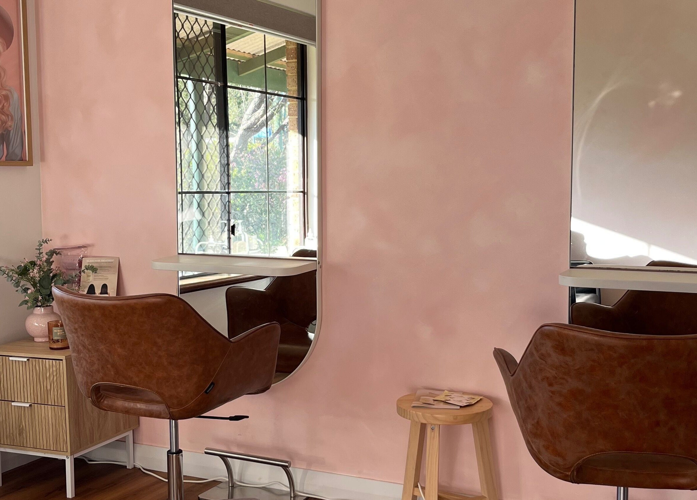 Stylish salon interior at Montana Jo Studio, Gingin, Western Australia, AU with pink walls and modern chairs.