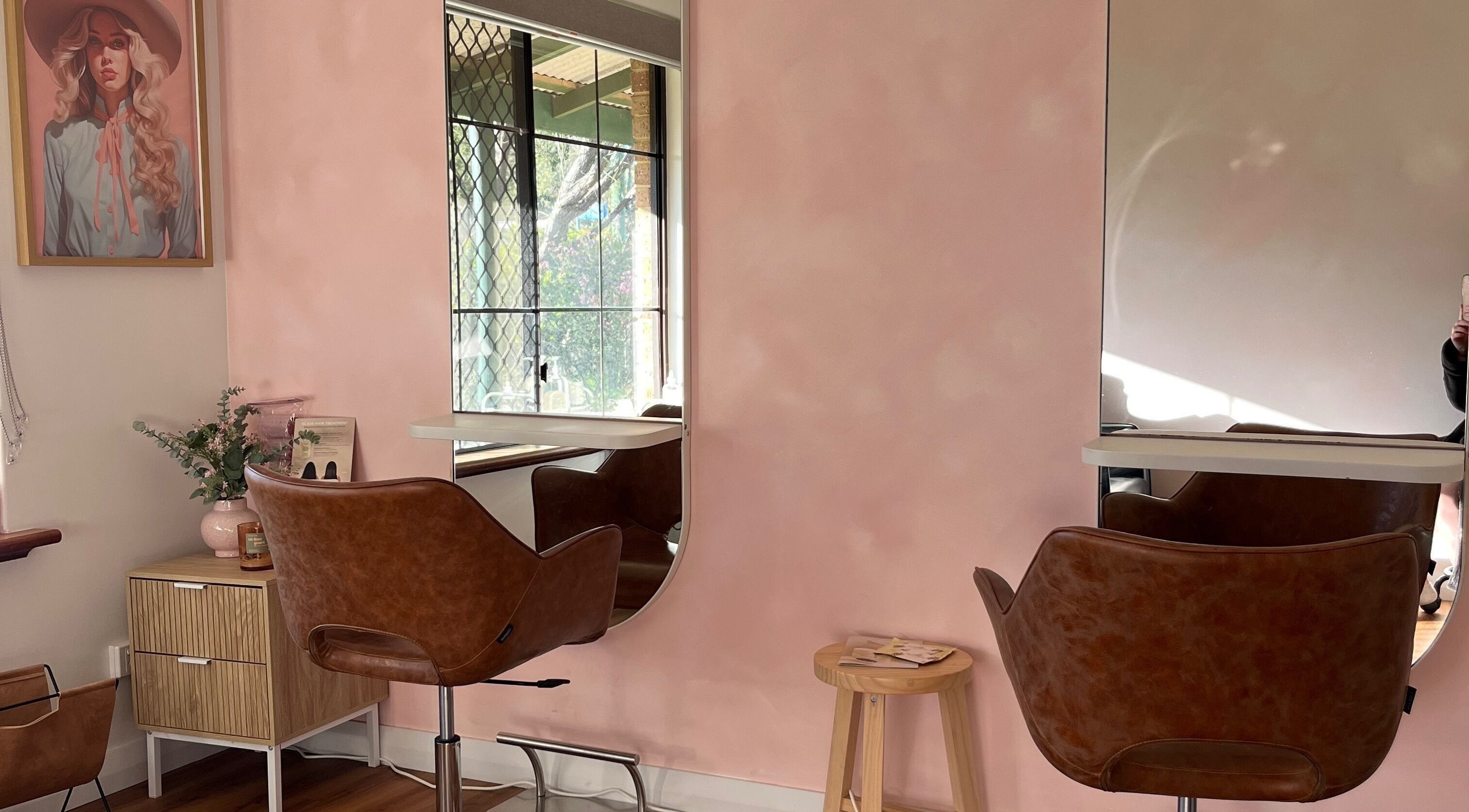 Stylish salon interior at Montana Jo Studio, Gingin, Western Australia, AU with pink walls and modern chairs.