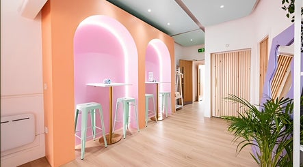 Bright and modern interior of The Glow Up Social in Manchester, England, GB with pastel tones and ambient lighting.