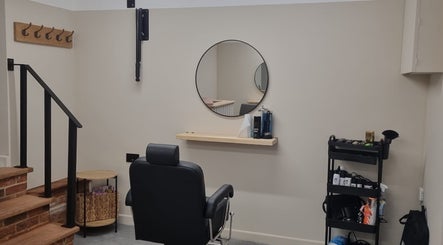Modern barber chair and mirror at Kyle’s Cuts, Watton, England, GB, showcasing sophisticated style.