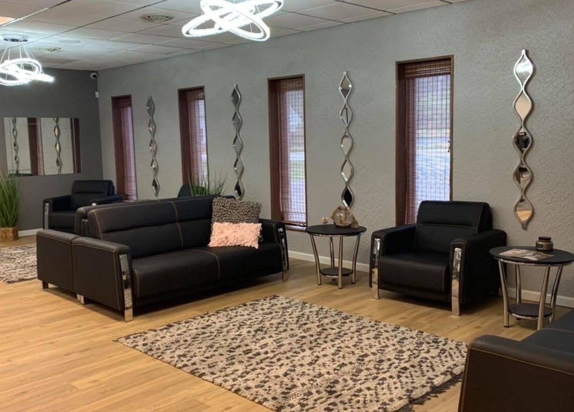 Modern lounge area at Beauty & Face Esthetics, Moline, Illinois, US, showcasing sleek sofas and stylish decor.