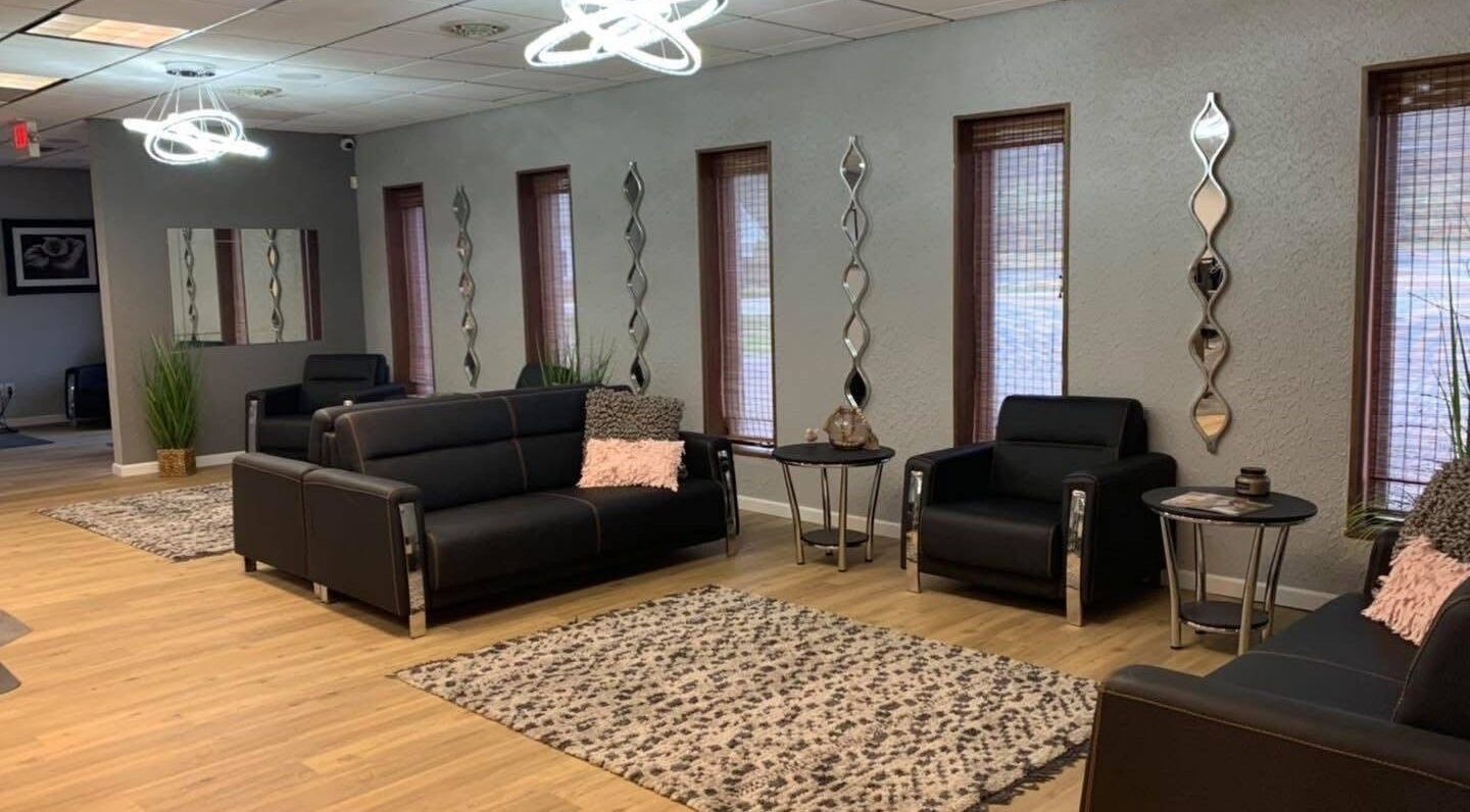 Modern lounge area at Beauty & Face Esthetics, Moline, Illinois, US, showcasing sleek sofas and stylish decor.