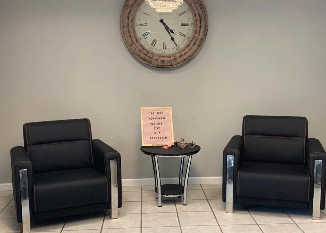 Inviting waiting area at Beauty & Face Esthetics in Moline, Illinois, US with plush chairs and a stylish clock.