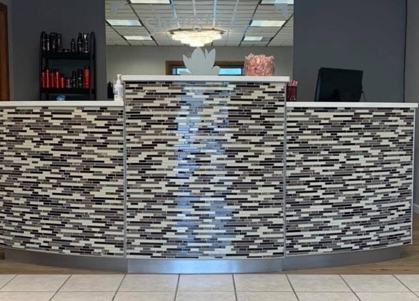 Elegant reception desk at Beauty & Face Esthetics in Moline, Illinois, US, showcasing sleek, tiled design.