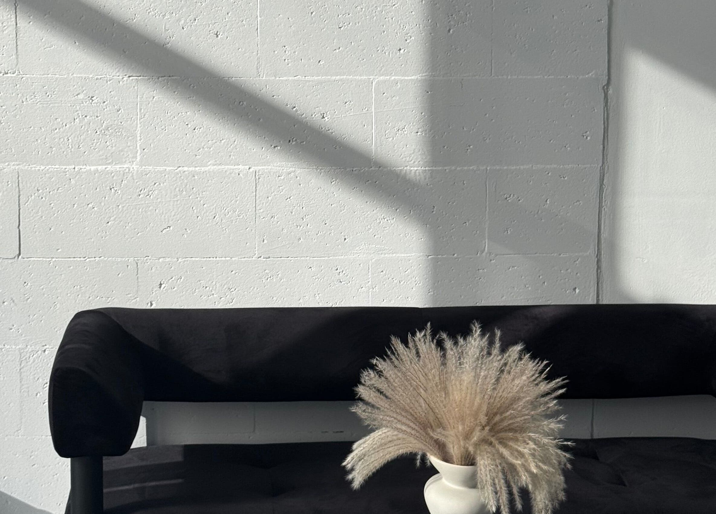 Стильний інтер'єр масажного салону “Saba” у Києві з чорним диваном та декоративною вазою.