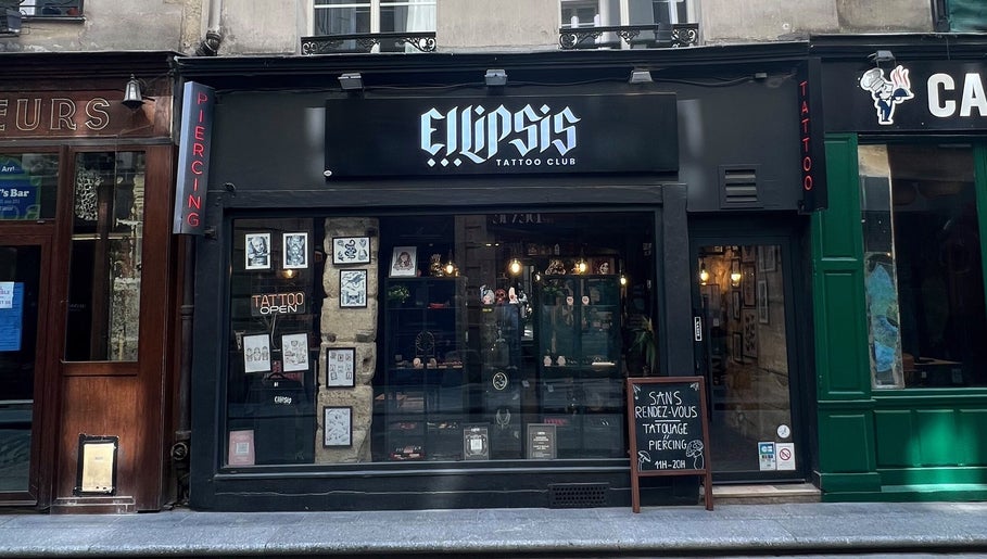 Front view of Ellipsis Tattoo Club in Paris, Île-de-France, FR showcasing artwork and signage.