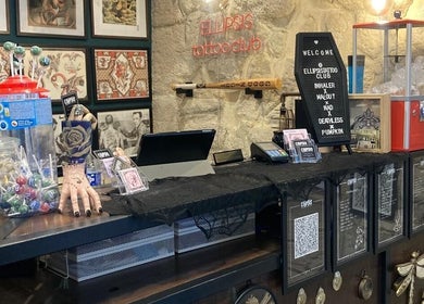 Ellipsis Tattoo Club in Paris, Île-de-France, FR features a vibrant reception with candy and wall art.