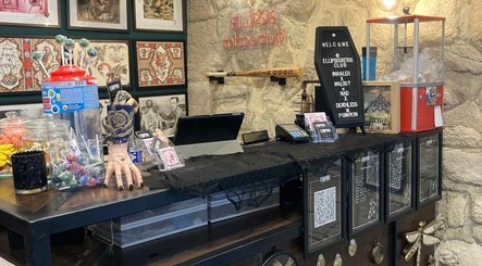 Ellipsis Tattoo Club in Paris, Île-de-France, FR features a vibrant reception with candy and wall art.