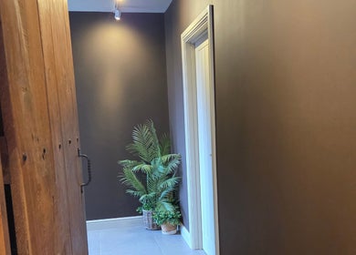 Elegant hallway at Rhiannon's Beauty Box, Long Melford, England, with wooden panels and a potted plant.