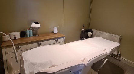 Cozy treatment room at Rhiannon's Beauty Box, Long Melford, England, GB. Elegant setup with a massage table.