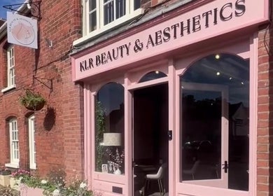 Entrance to Rhiannon's Beauty Box in Long Melford, England featuring a charming pink storefront.