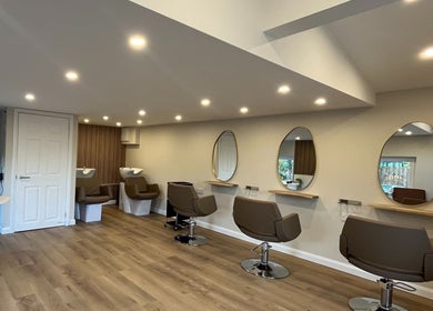 Modern salon chairs and mirrors at Hidden Lane Hair in Winchburgh, Scotland, GB, showcasing a serene ambiance.
