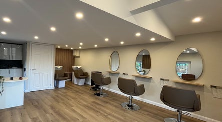 Modern salon chairs and mirrors at Hidden Lane Hair in Winchburgh, Scotland, GB, showcasing a serene ambiance.