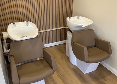 Modern wash stations at Hidden Lane Hair, Winchburgh, Scotland, GB, featuring sleek brown chairs and basins.