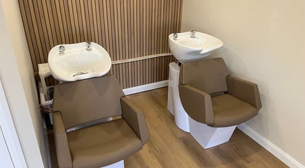 Modern wash stations at Hidden Lane Hair, Winchburgh, Scotland, GB, featuring sleek brown chairs and basins.