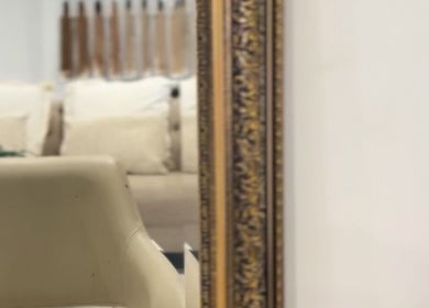 Elegant beige seating reflected in ornate mirror at Lily Solomon hair, Melbourne, Victoria, AU.