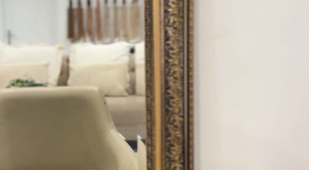 Elegant beige seating reflected in ornate mirror at Lily Solomon hair, Melbourne, Victoria, AU.