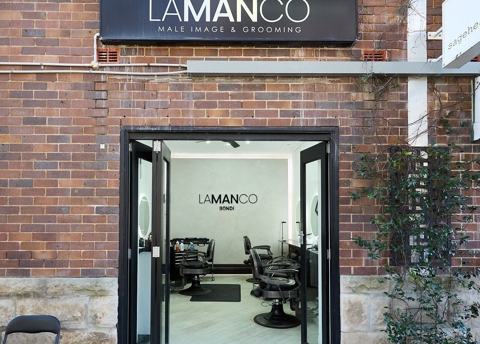 Entrance of Lamanco Barbershop at Bondi Beach, New South Wales, AU showing modern decor and styling stations.