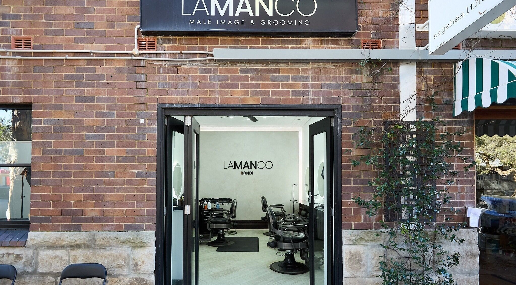 Entrance of Lamanco Barbershop at Bondi Beach, New South Wales, AU showing modern decor and styling stations.