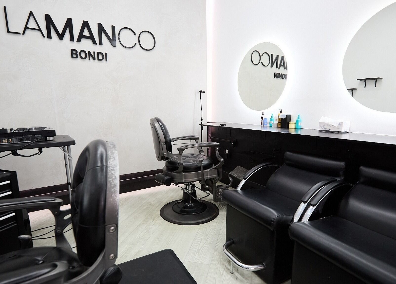 Interior of Lamanco Barbershop, Bondi Beach, NSW, featuring stylish black chairs and sleek mirrors.
