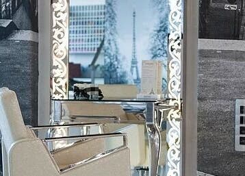 Modern styling chair and ornate mirror at Veaudry International JOHANNESBURG in Johannesburg, Gauteng, ZA.