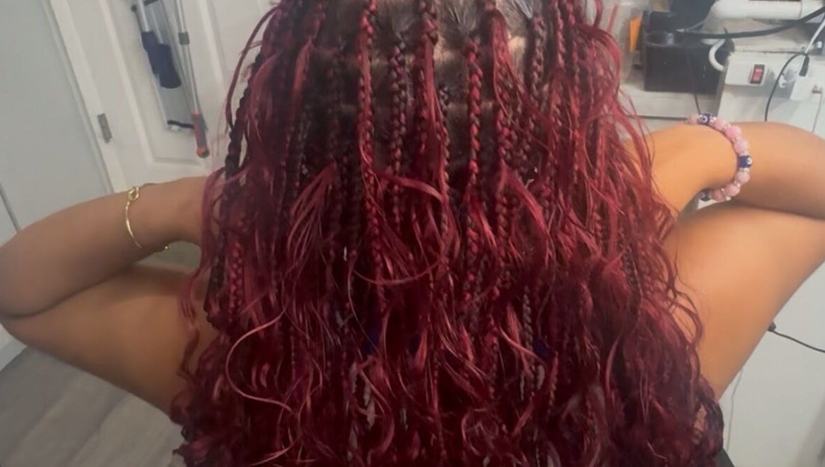 Vibrant red braids styled elegantly at Bibii Hair in Miramar, Florida, US.