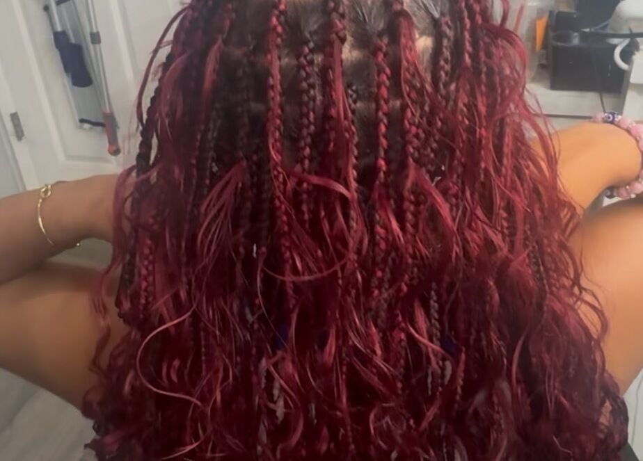 Vibrant red braids styled elegantly at Bibii Hair in Miramar, Florida, US.