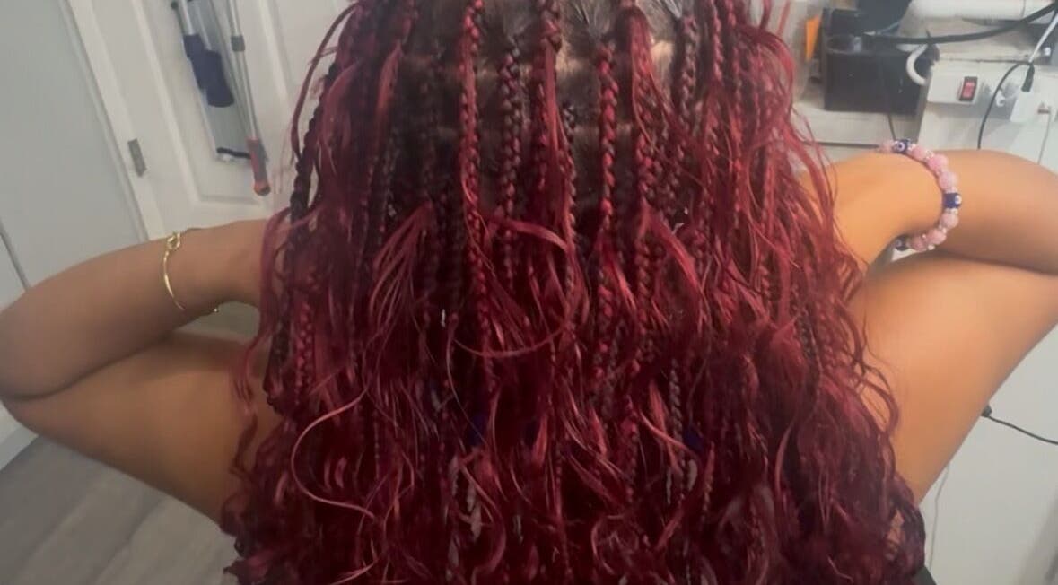 Vibrant red braids styled elegantly at Bibii Hair in Miramar, Florida, US.