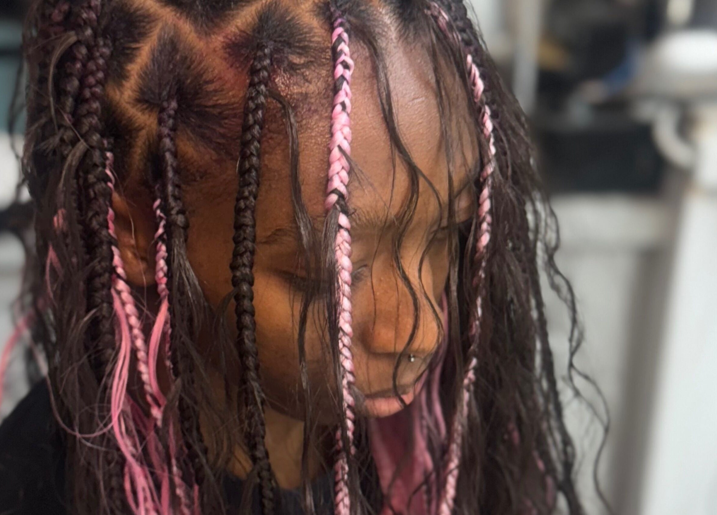 Intricate pink braided hairstyle at Bibii Hair, Miramar, Florida, US highlighting vibrant style and creativity.