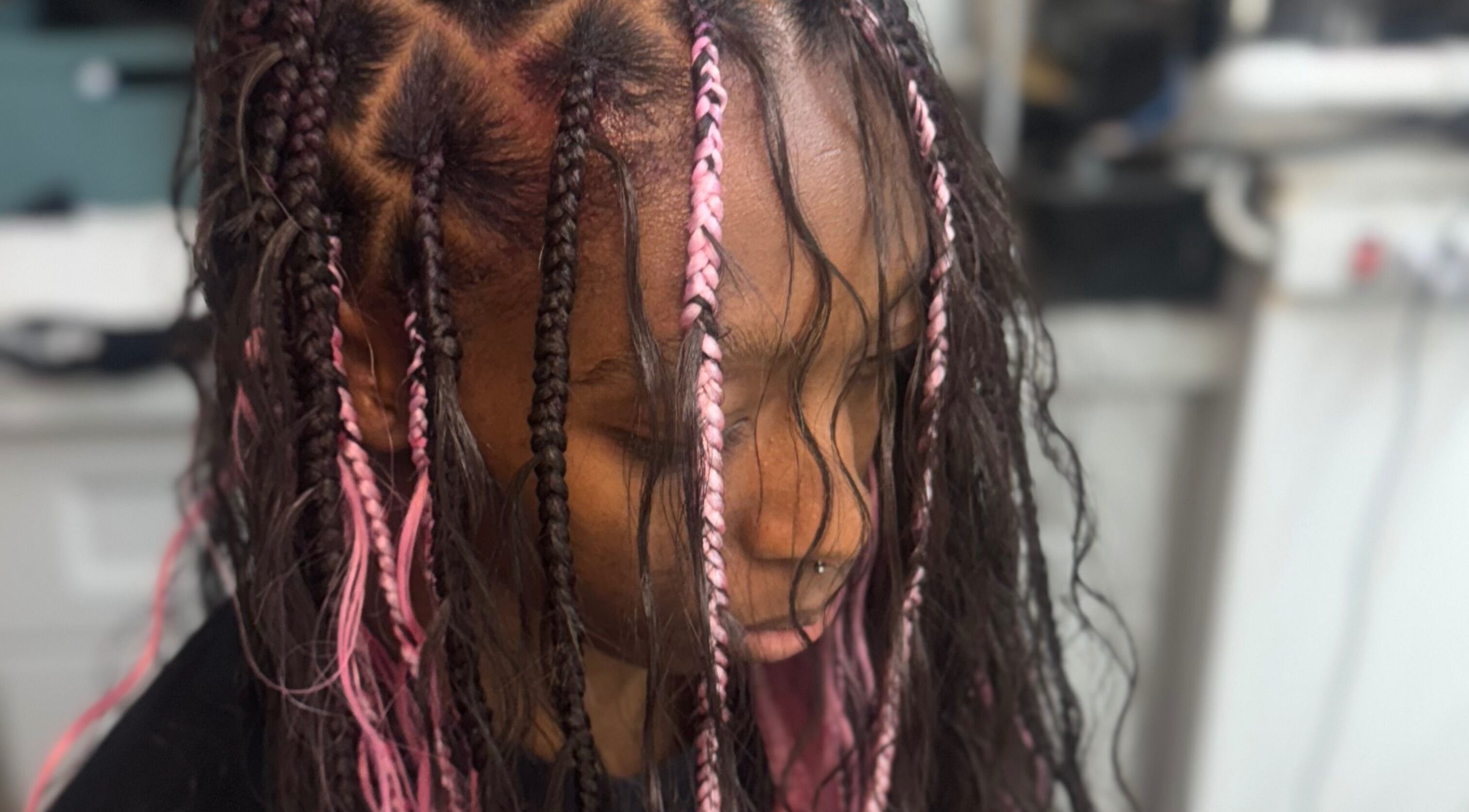Intricate pink braided hairstyle at Bibii Hair, Miramar, Florida, US highlighting vibrant style and creativity.