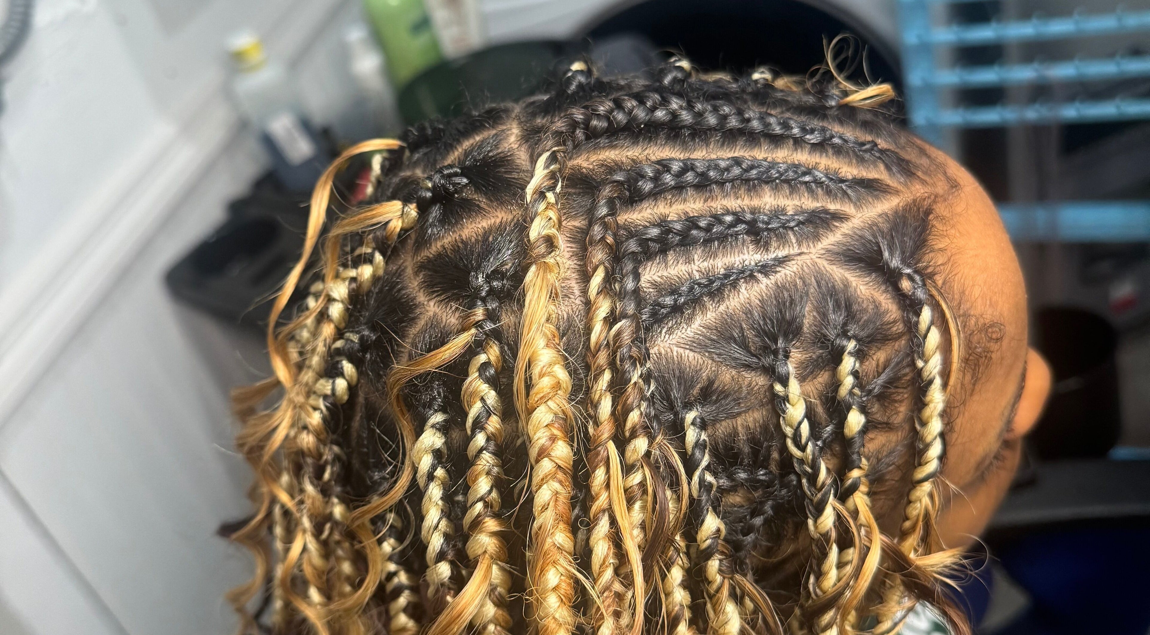 Intricate braided hairstyle with highlights at Bibii Hair in Miramar, Florida, US.
